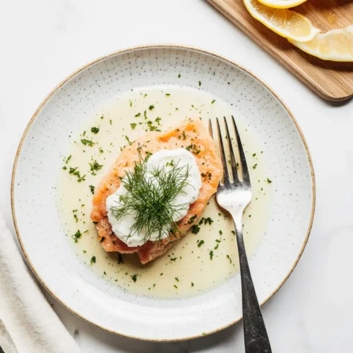 Homemade gefilte fish recipe served on a platter with herbs.