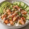 Smoked salmon rice bowl with avocado cucumber scallions and chili crisp