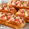 Four Maine-style lobster rolls with chilled lobster in lemon-chive mayonnaise on butter-toasted split-top buns