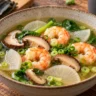 Clear kombu dashi shrimp soup with shiitake mushrooms, daikon radish, spinach and scallions