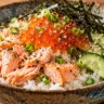 Rice bowl topped with fully cooked salmon, salmon roe, cucumber, scallions and shredded nori